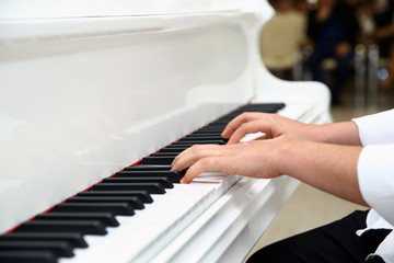 Little boy playing the piano at home . White piano . Azerbaijan Baku 21.02.2020 .