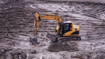 Workers in the mud of a construction site at the stage of excavation; construction of a supermarket...