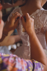 Obraz na płótnie Canvas Helping the bride to put her wedding dress on