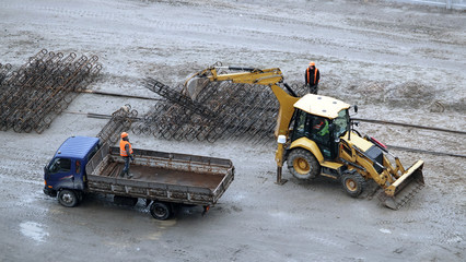 Tractors and excavators work on the construction of the foundation zero cycle