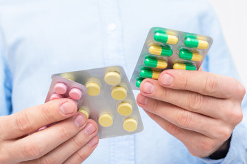 Concept of  healthcare. Person shows a green pills in blister packs, close up