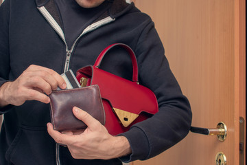 Pilferer with women wallet, man stole a woman's bag, purse and credit card, close up