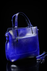 Beautiful blue women's comfortable bag with large handles. It will look beautiful with any clothes. Photo bags on a black background.