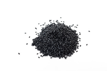 Plastic polymer granules black color on white background. Polycarbonate granules for the production of translucent structures and cellular polycarbonate