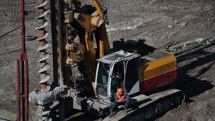 Drilling rig boring the ground pours a hole in the concrete for the foundation of the house