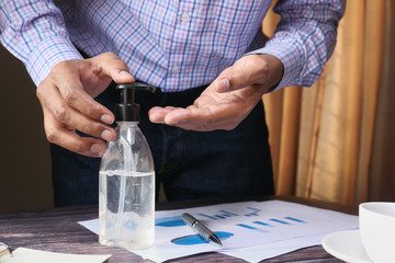 Businessman work in office room using hand sanitizer.