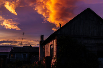 At an old wooden house in the late evening sunset before the storm
