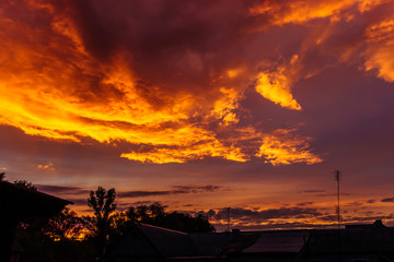 Dark sunset sky over houses on a summer evening, storm clouds