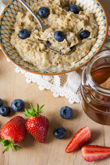 Healthy breakfast - porridge oatmeal with blueberries and strawberries, vegan and gluten free, organic home made meal.