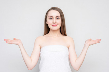 Woman in a towel shows palms free space for advertising, empty space, portrait, white background