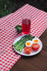 Breakfast with asparagus, egg and tomatoes. Vegetables. Vegetarian food on the table