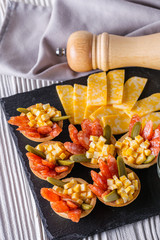 delicious snack tartlets on rustic wooden background
