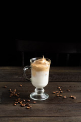 Dalgona korean coffee - trendy drink with whipped instant coffee and milk. Popular iced drink.Whipped milk cold shaked coffee. quarantine trend. Dark background. Copy space.