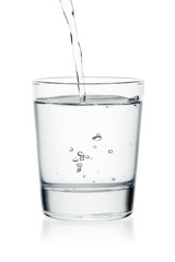 Pouring water on a glass isolated on a white background.