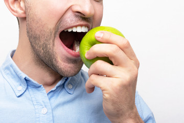 Concept of a healthy and healthy diet. Man bites an Apple , closeup, cropped image, white background