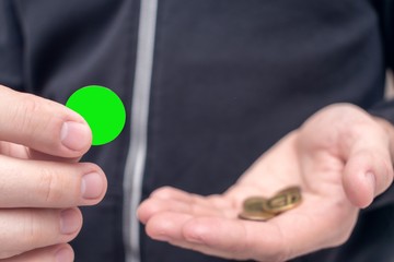 Man shows coin template, man's hands, closeup, cropped image, toned