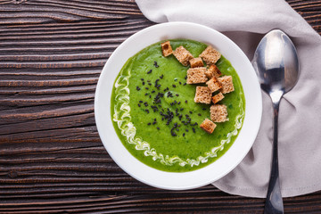 broccoli spinach cream soup on rustic wooden background