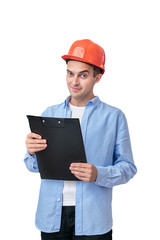 Constructor in helmet looks at the camera, man holding a notepad, isolated background, vertical