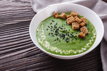 broccoli spinach cream soup on rustic wooden background