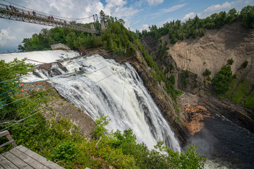 Fototapeta na wymiar Montmorency waterfall from the bush. Only 10kms away from Quebec City. That waterfall is amazing because superpowerful. You can feel the power of it when you hear the water smashing downside