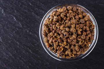 Sichuan pepper on a dark stone background