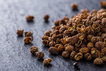 Sichuan pepper on a dark stone background