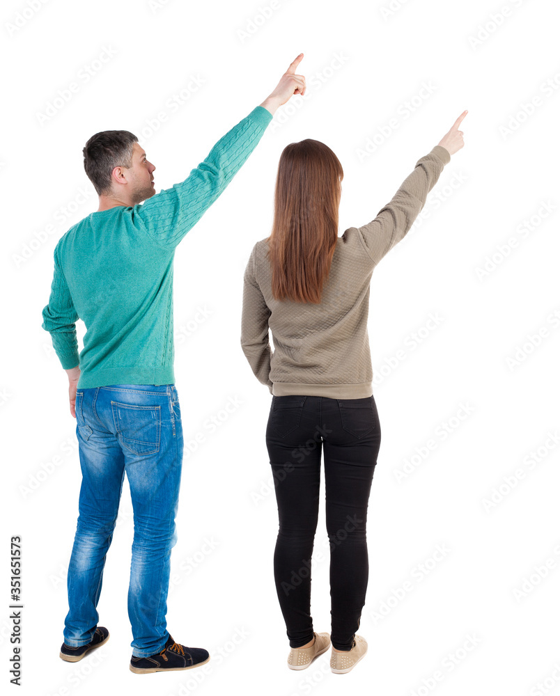 Wall mural Back view of couple in sweater pointing.