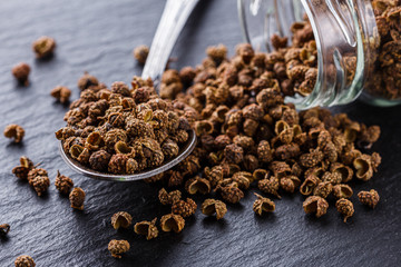 Sichuan pepper on a dark stone background