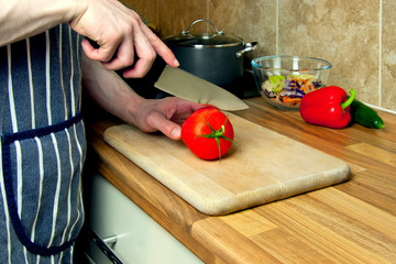 View of a man`s hands preparing homemade dinner with a healthy salad