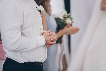 Bride and groom praying before wedding reception in restaurant, traditions. Group of guests praying before feast, hands close up