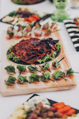 Delicious appetizer and canape on table at wedding reception in restaurant. Luxury catering service. Italian delicatessen, prosciutto snacks, cheese and olives. Christmas feast