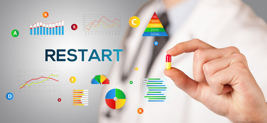 Nutritionist giving you a pill with RESTART inscription, healthy lifestyle concept