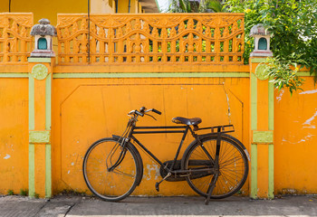 Old bicycle in front of bright yellow wall, Mahabalipuram (Mamallapuram), India - 351655176