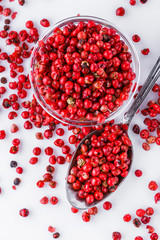 fragrant pink peppercorns on white acrylic background