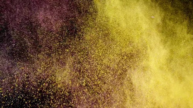 Exotic spices collide on black background. Slow motion. Explosion. Pink and yellow powder. Full HD 240 fps