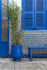 Blue flowerpot, shuttered window and bench in front of wall mosaics, Marrakech (Marrakesh), Morocco - 351656945