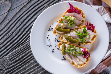 delicious snack tartlets on rustic wooden background