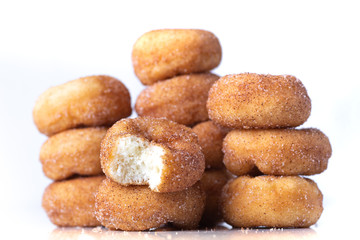 Cinnamon Sugar Mini Donuts in a stack on white background 