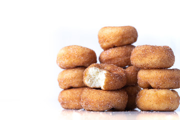 Cinnamon Sugar Mini Donuts in a stack on white background with copy space