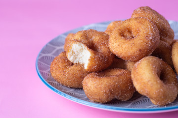Cinnamon Sugar Mini Donuts on a plate with bite eaten