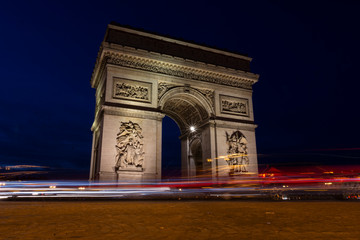 Fototapeta na wymiar Paris triumphal arch at night, it is a long exposure in the blue hour with the traces of the lights of the cars