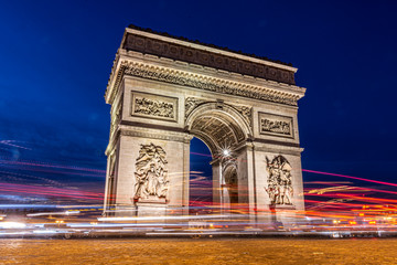 Paris triumphal arch at night, it is a long exposure in the blue hour with the traces of the lights of the cars