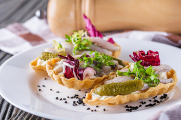 delicious snack tartlets on rustic wooden background