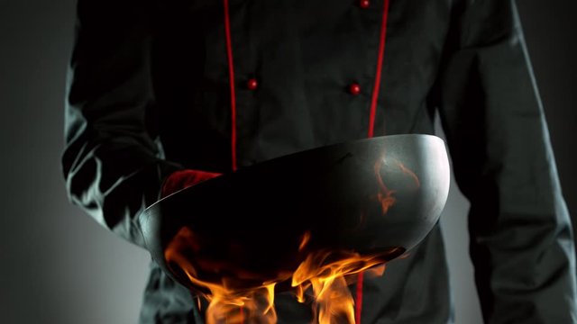 Super slow motion of closeup of chef with empty wok pan and fire. Filmed on high speed cinema camera, 1000 fps.