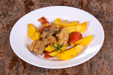 Baked pork meat with potao and tomato