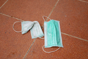 used surgical mask on the floor. discarded mask. The mask that was discarded after the virus spread.