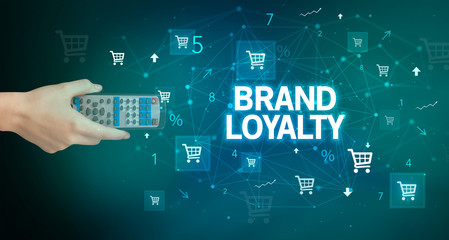 hand holding wireless peripheral with BRAND LOYALTY inscription, online shopping concept