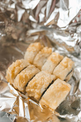 Japanese food delivery service rolls in plastic box and foil, hot and baked rolls, food delivery quarantine house fast food hunger lunch dinner sushi