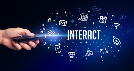 hand holding wireless peripheral with INTERACT inscription, social media concept