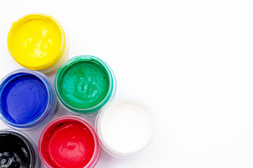 Cans of different colors gouache paints, top view, closeup, white background, copy space